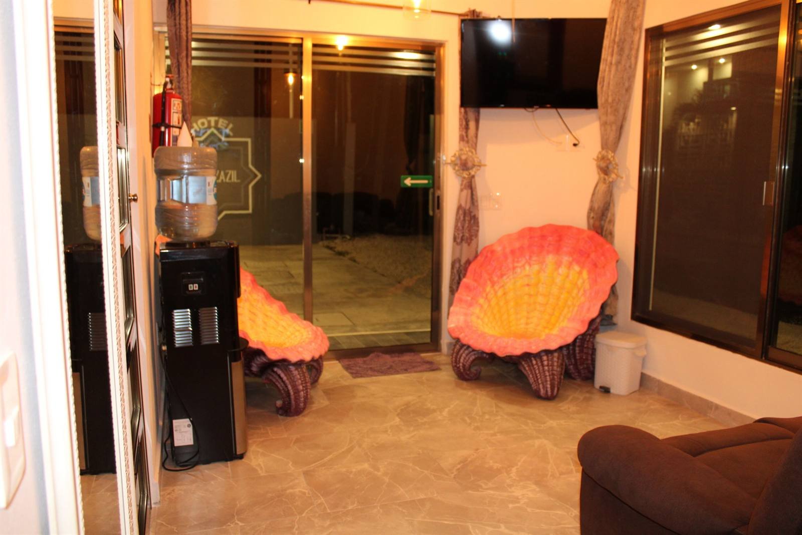 Reception area with shell-shaped armchairs and a water dispenser